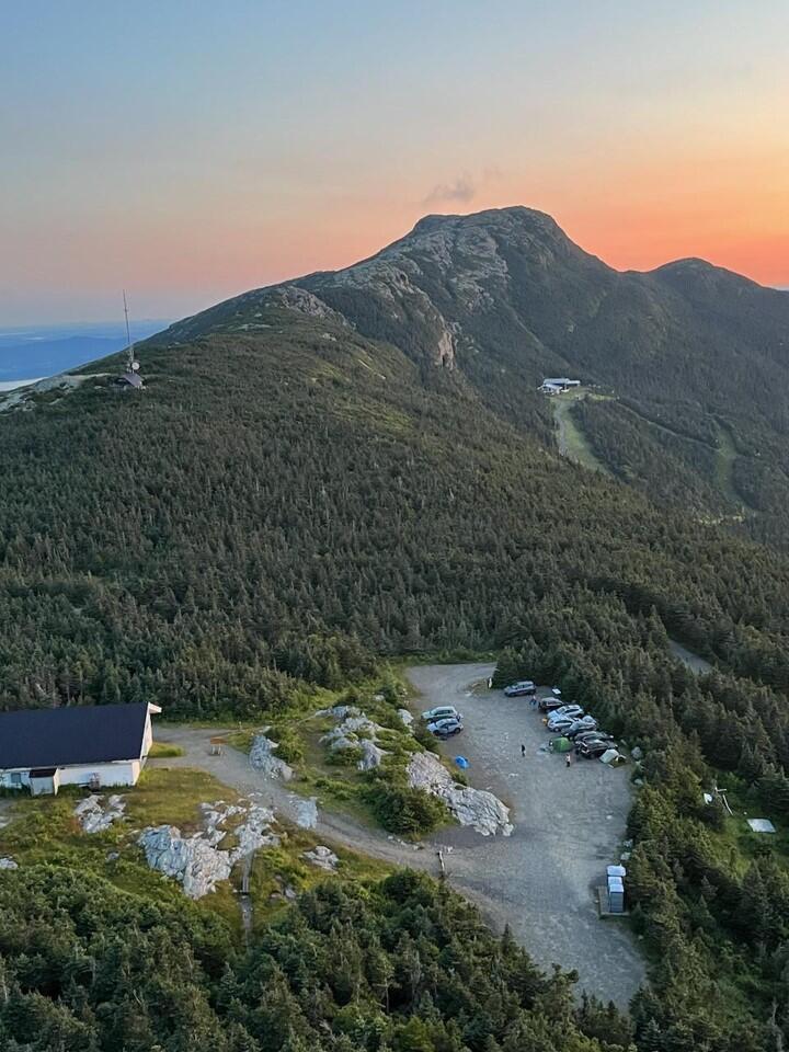 View of a mountain with a facility and parking lot in the foreground