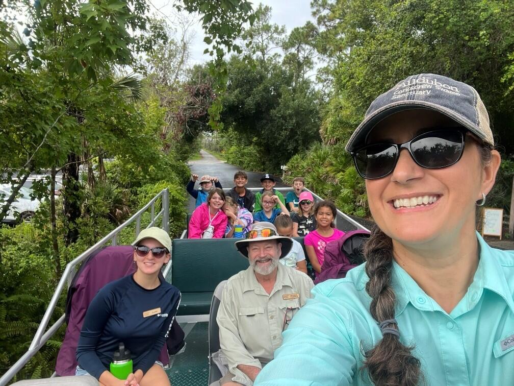 Campers and counselors riding on a swamp buggy.