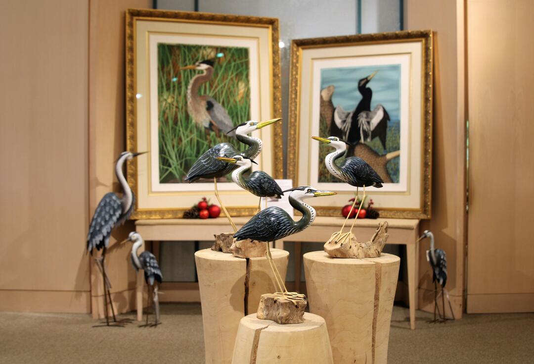 Store interior with large portraits and bird sculptures.