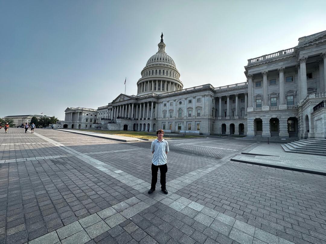 A young man standing in front of the U.S. Capitol